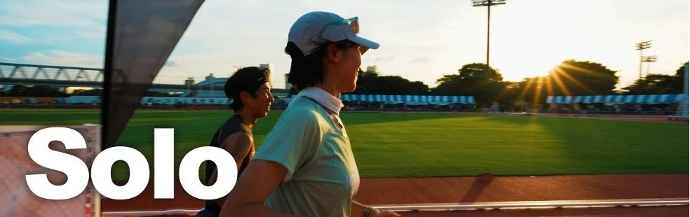 夕暮れのトラックを走るランナー