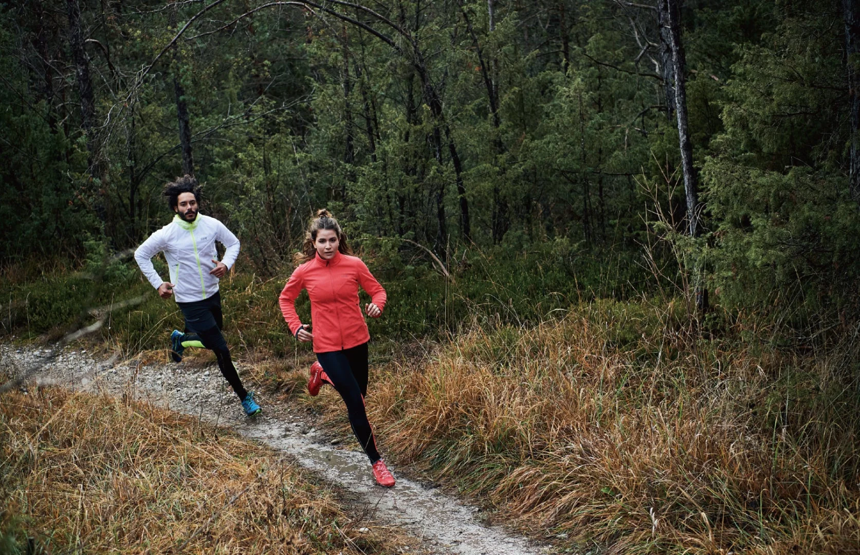森の中をトレイルランニングする男女
