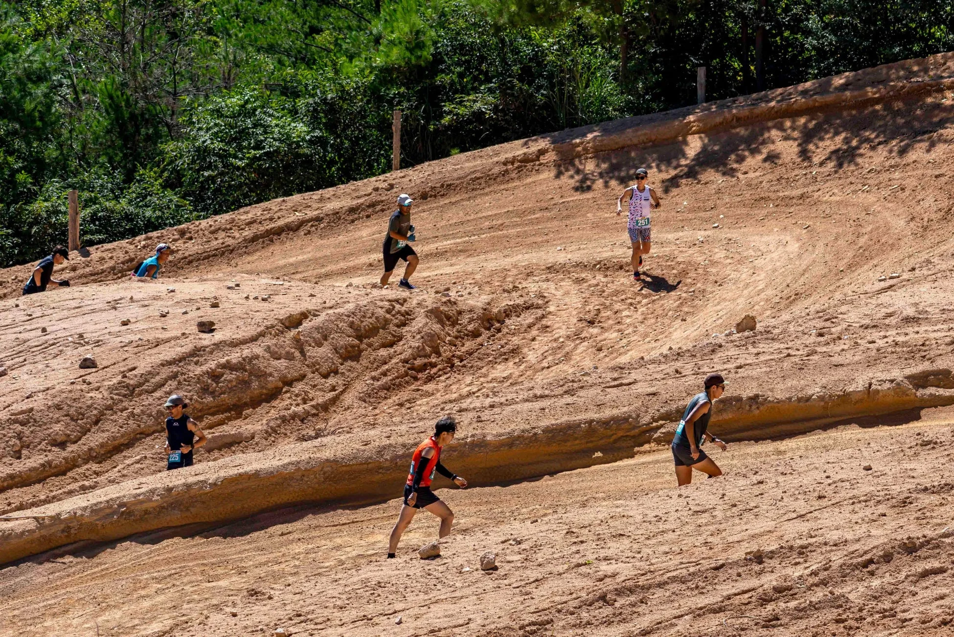 砂地の急坂を登るランナー