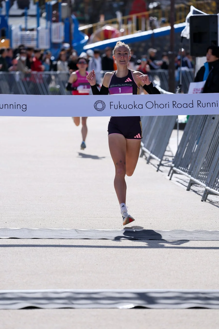 ゴールラインを通過する女性ランナー