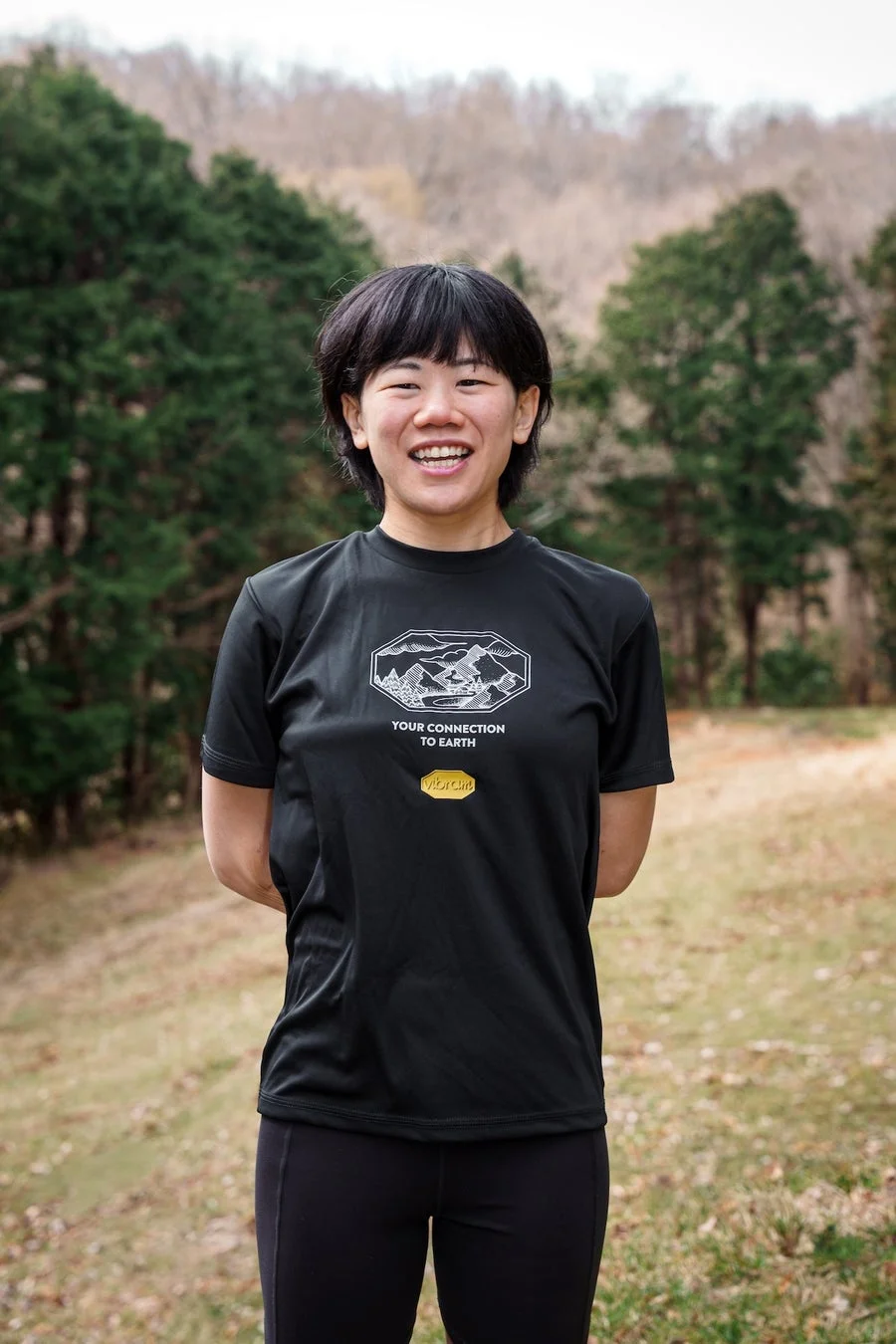 自然の中で笑顔を見せるアジア人女性