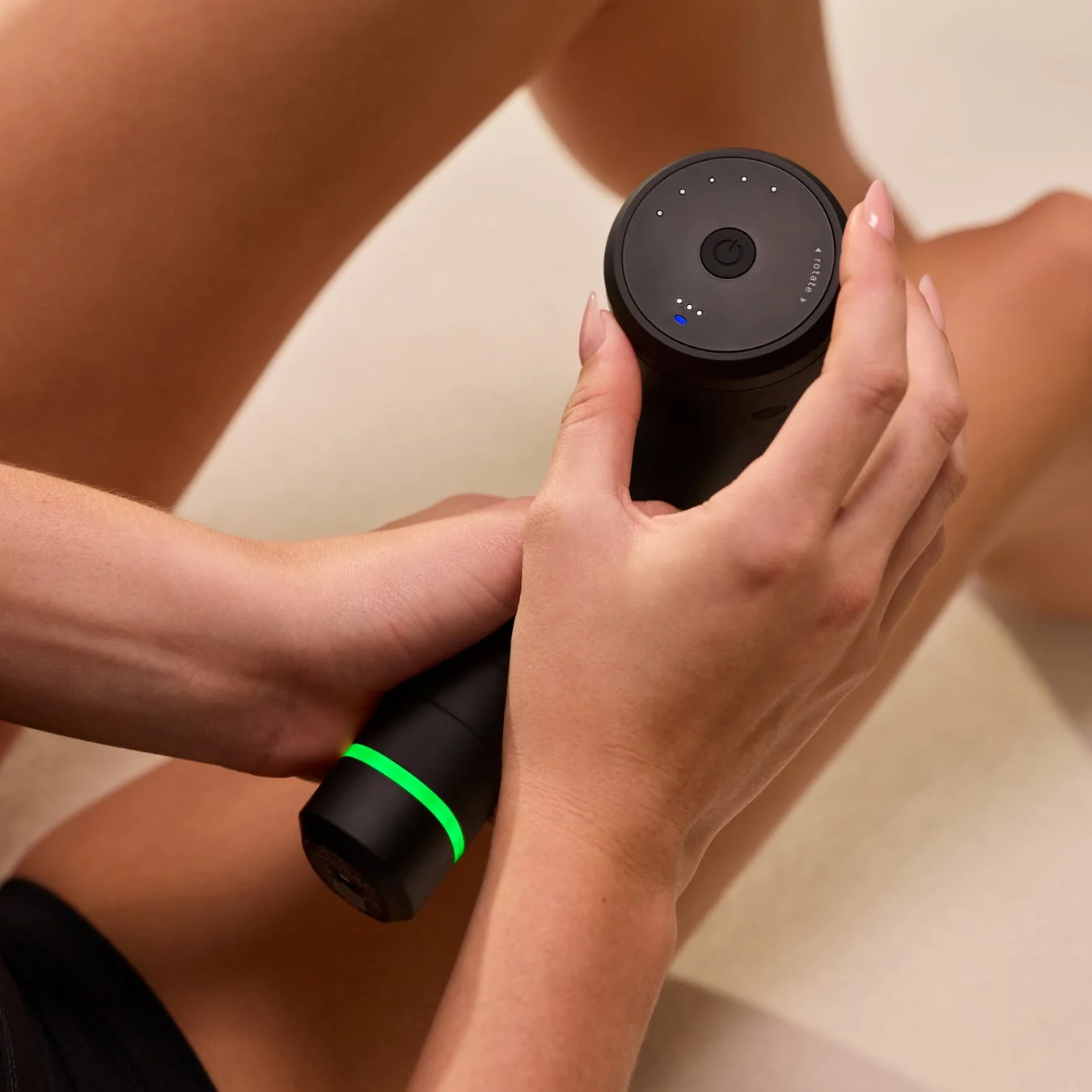 女性が脚にマッサージガンを使用