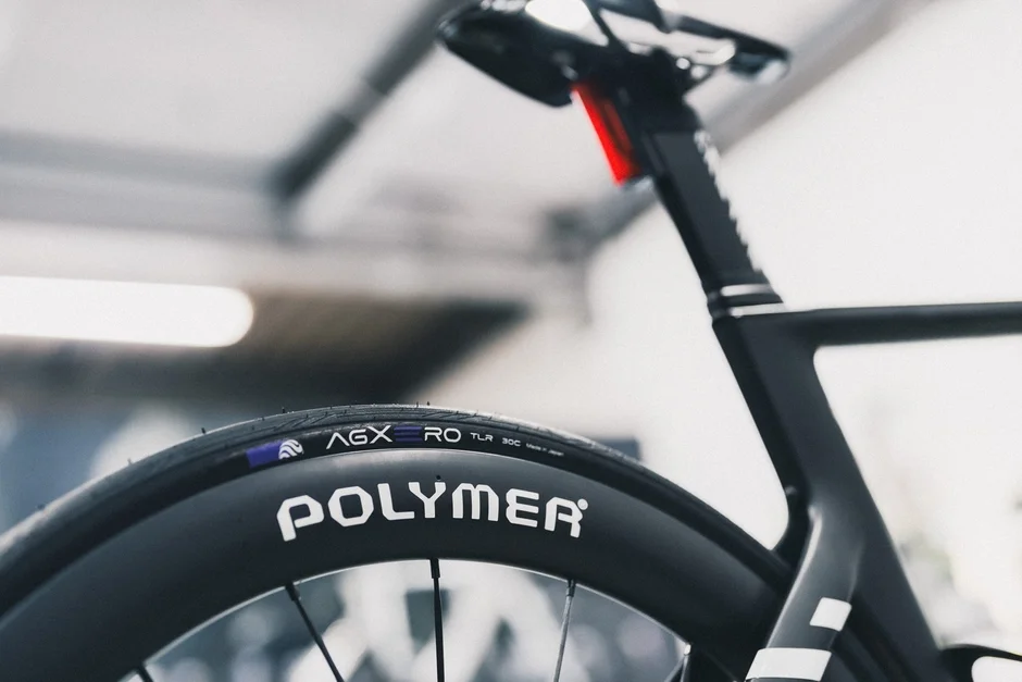 現代的な黒い自転車の後輪とフレームの一部をクローズアップで捉えた画像です。