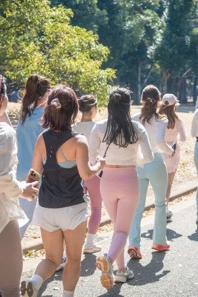 公園の道をジョギングする女性たちのグループ