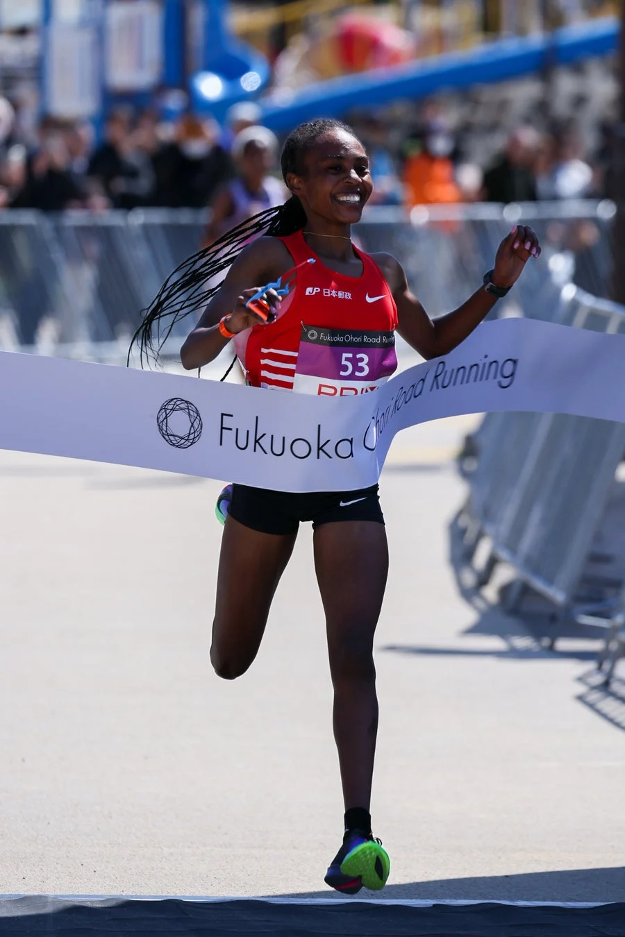 笑顔でフィニッシュする女性ランナー