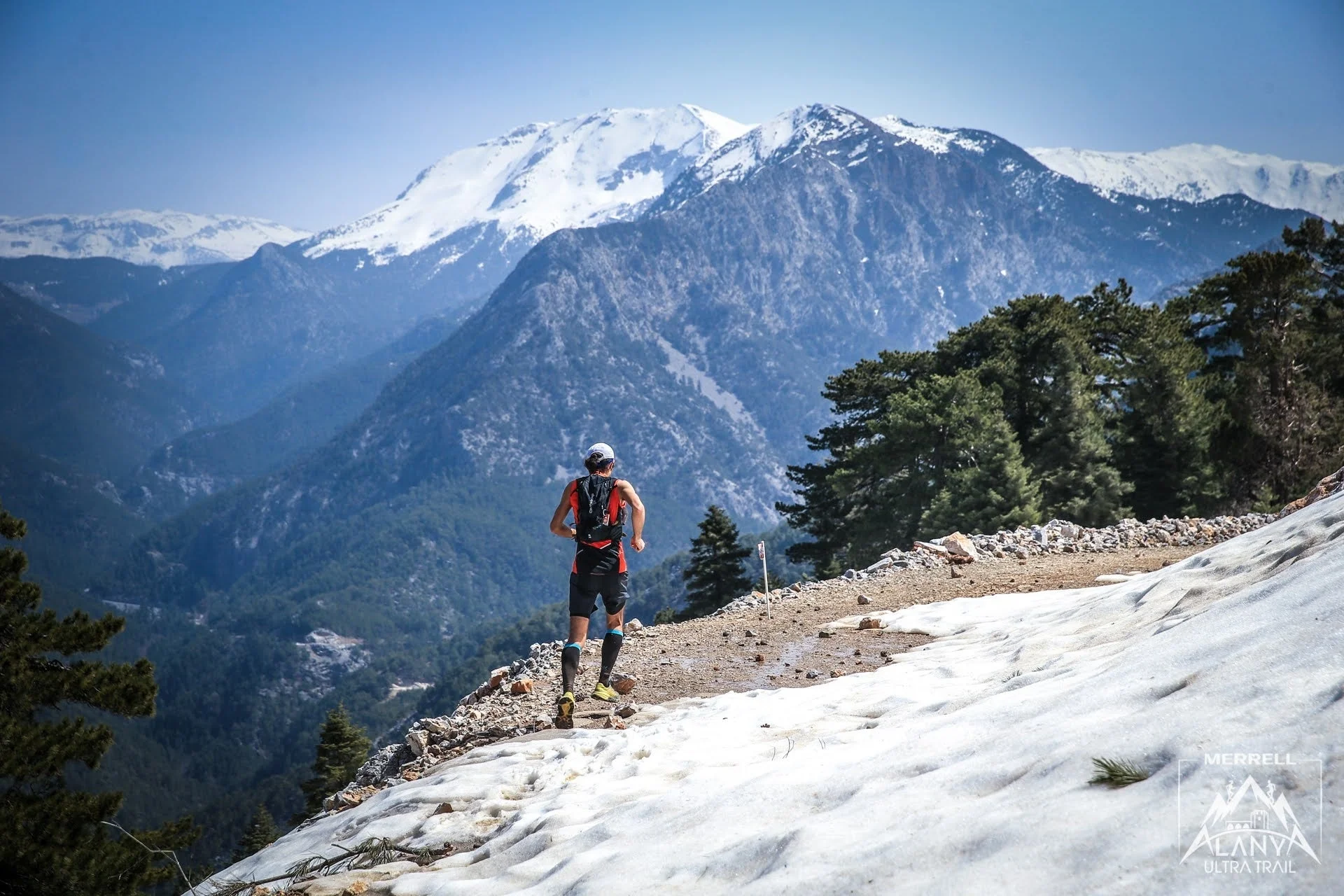 雪が残る山道を走るランナー
