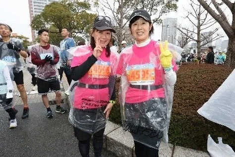ピンクのシャツとビニールポンチョを着た2人の女性