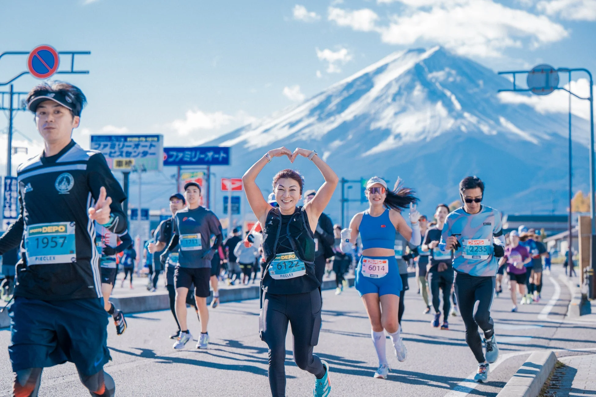 晴れた日に富士山を背景に多くのランナーがマラソンに参加している様子