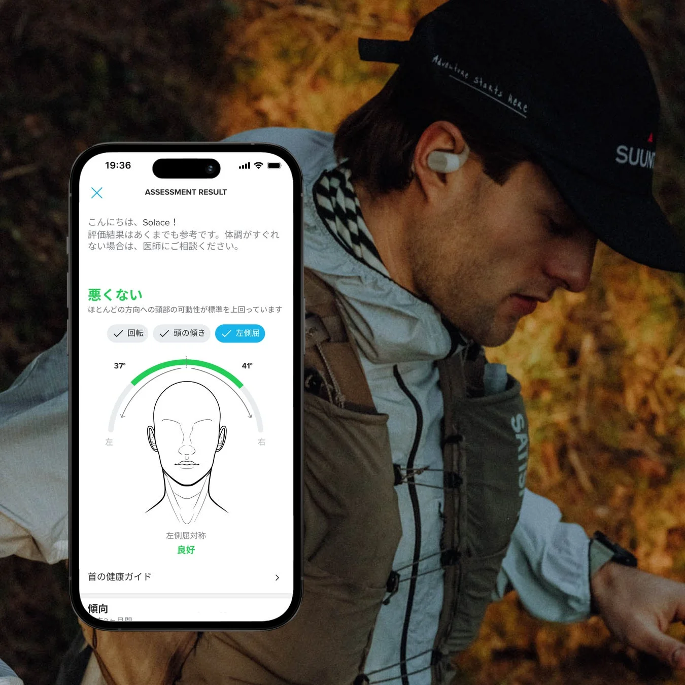 スマートフォンアプリで首の健康状態の評価結果が表示されており、頭部の可動域と左右対称性が「良好」と示されています。背景にはSuuntoのキャップとワイヤレスイヤホンを着用した男性が写っており、アクティブなライフスタイルを連想させます。