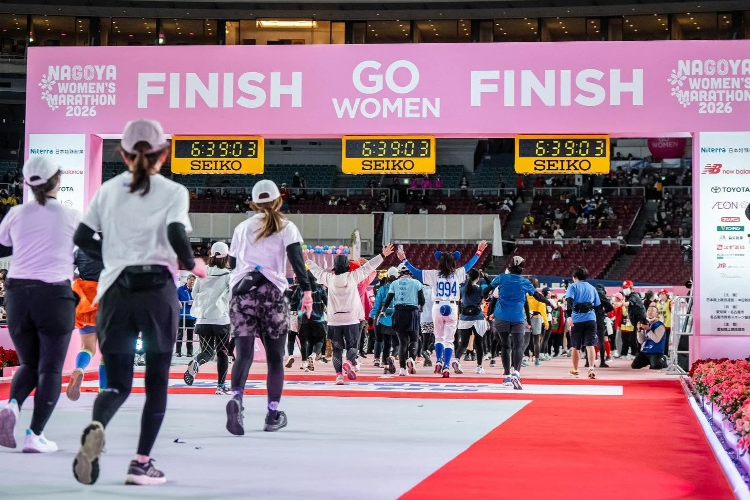 名古屋ウィメンズマラソン2026のフィニッシュラインを多くの女性ランナーが駆け抜けている様子