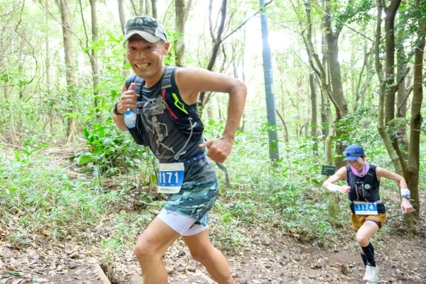 森の中をトレイルランニングするランナー